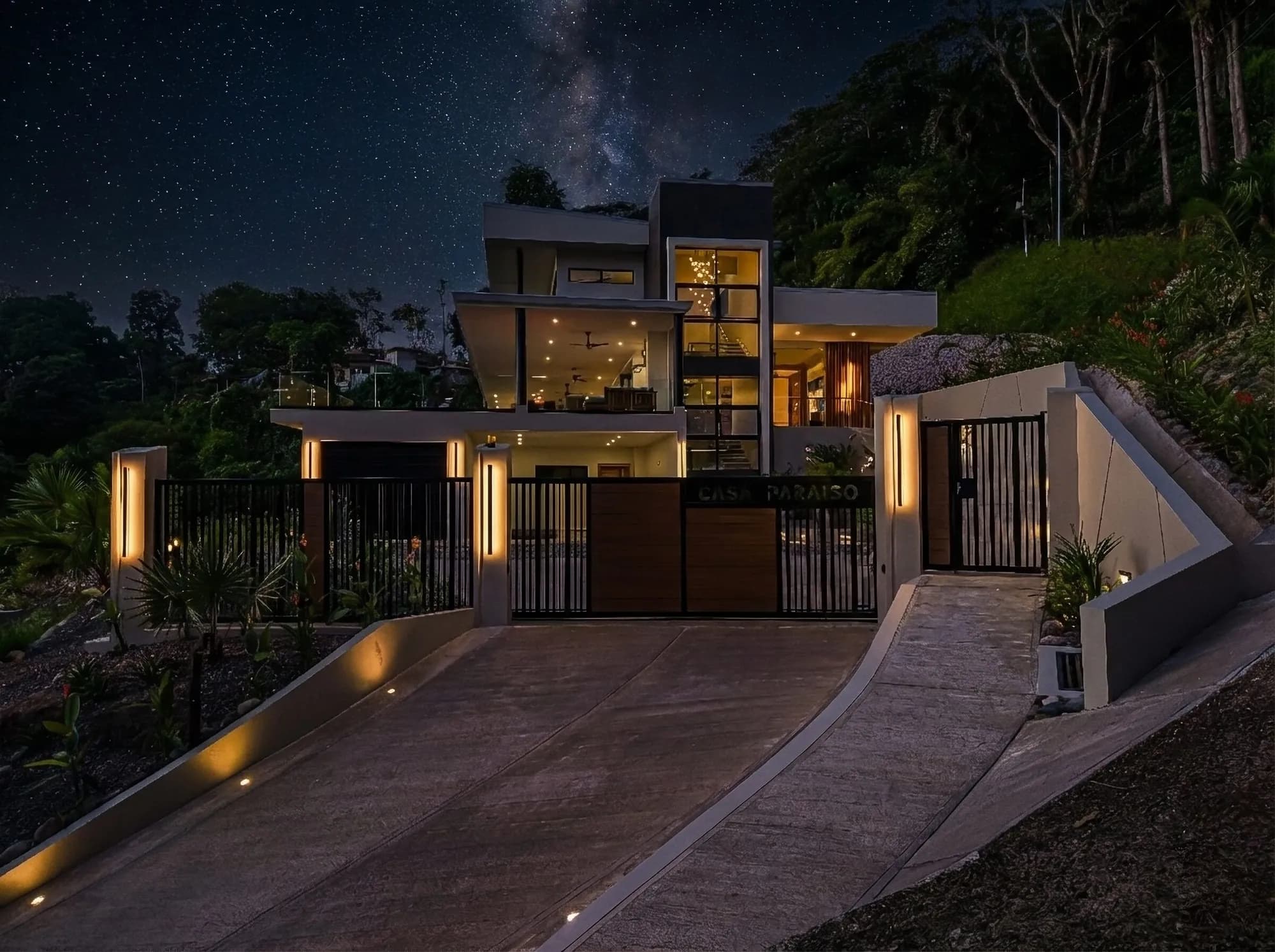 The entrance of Casa Paraiso at night, lit by path lights, with the Milky Way above the trees.